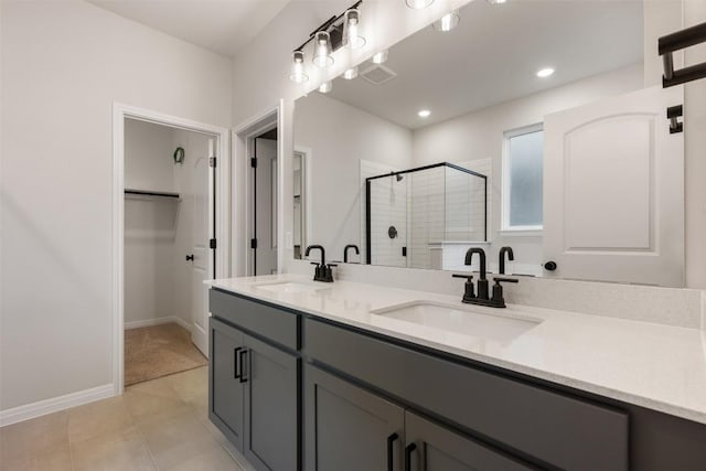 727 Palo Brea Loop, Hutto, TX 78634 - bathroom with a stall shower, double vanity, a spacious closet, baseboards, and tile patterned floors
