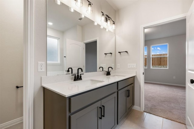 727 Palo Brea Loop, Hutto, TX 78634 - bathroom featuring double vanity, baseboards, and tile patterned floors