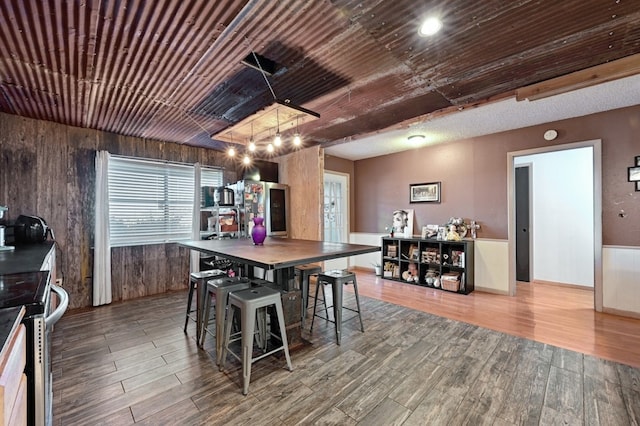 dining space with wooden walls and hardwood / wood-style floors