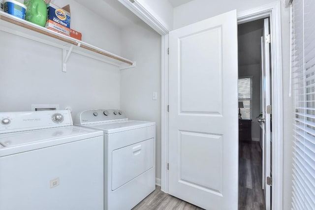 laundry area featuring washing machine and clothes dryer and light wood-type flooring