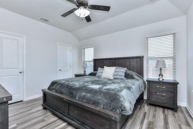 bedroom with ceiling fan, lofted ceiling, and light wood-type flooring