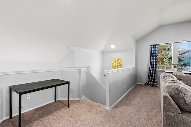 hallway featuring light carpet, a healthy amount of sunlight, and vaulted ceiling