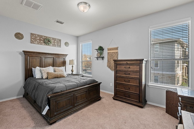 bedroom with multiple windows and light colored carpet