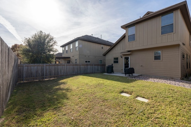 back of house with a yard and a patio