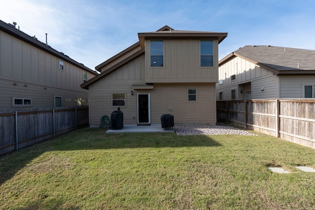 back of property with a yard and a patio