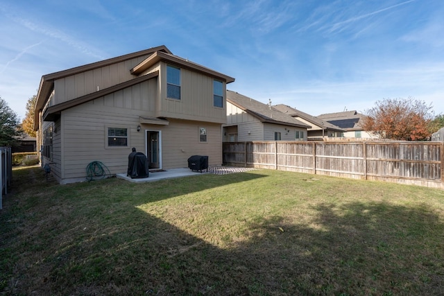 rear view of property featuring a patio area and a lawn