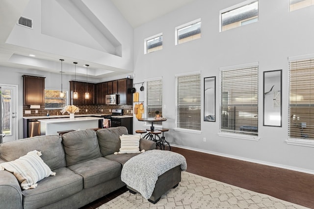 living room with dark hardwood / wood-style flooring and a high ceiling