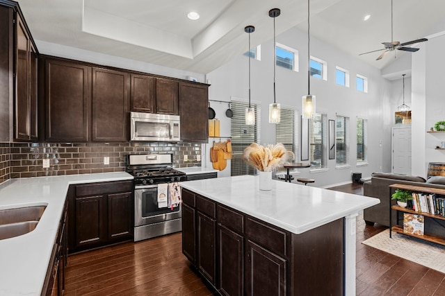 kitchen with decorative backsplash, appliances with stainless steel finishes, decorative light fixtures, and dark brown cabinets