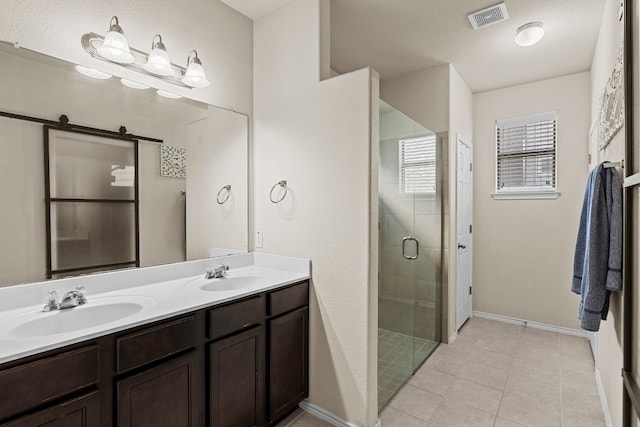 bathroom featuring tile patterned flooring, vanity, and a shower with shower door