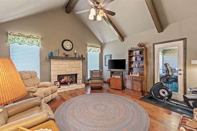 living room featuring a fireplace, wood-type flooring, vaulted ceiling with beams, and plenty of natural light