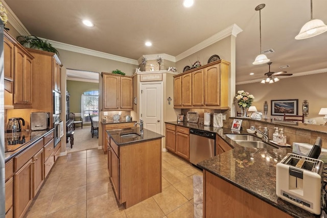 kitchen featuring appliances with stainless steel finishes, decorative light fixtures, ornamental molding, and sink