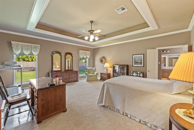 carpeted bedroom with ceiling fan, a raised ceiling, and ornamental molding