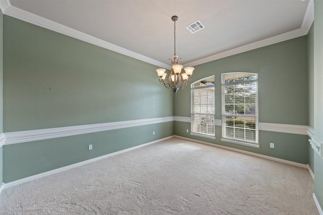 carpeted empty room featuring crown molding and a notable chandelier