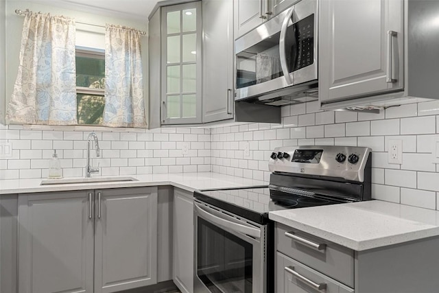 kitchen featuring gray cabinets, sink, and appliances with stainless steel finishes