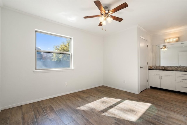 unfurnished bedroom featuring ceiling fan, crown molding, dark hardwood / wood-style floors, and sink