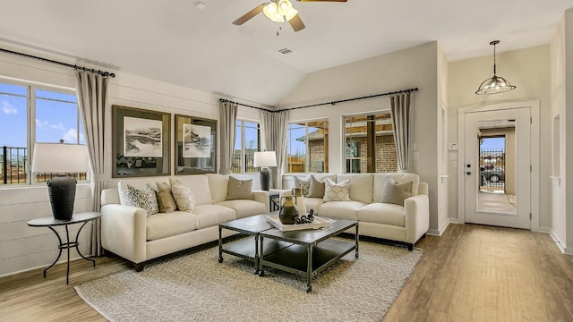 living room with ceiling fan, lofted ceiling, and light wood-type flooring