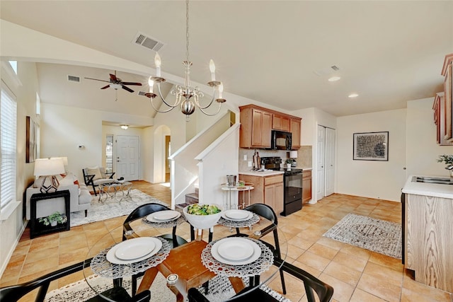 tiled dining area with ceiling fan with notable chandelier, a healthy amount of sunlight, lofted ceiling, and sink