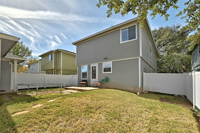 rear view of house with a patio and a lawn