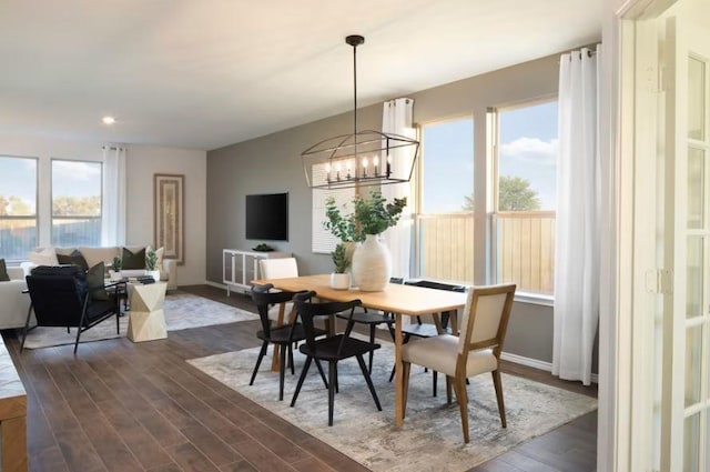 dining area with dark hardwood / wood-style flooring and an inviting chandelier