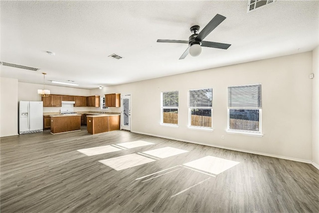 unfurnished living room with ceiling fan, hardwood / wood-style floors, and a textured ceiling