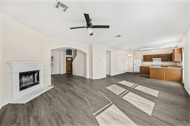 unfurnished living room with ceiling fan and dark wood-type flooring