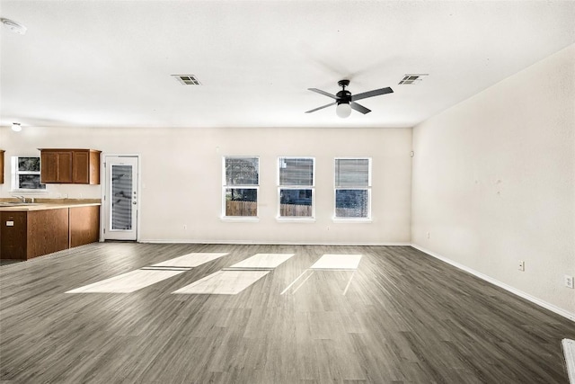 unfurnished living room featuring ceiling fan, dark hardwood / wood-style flooring, and sink