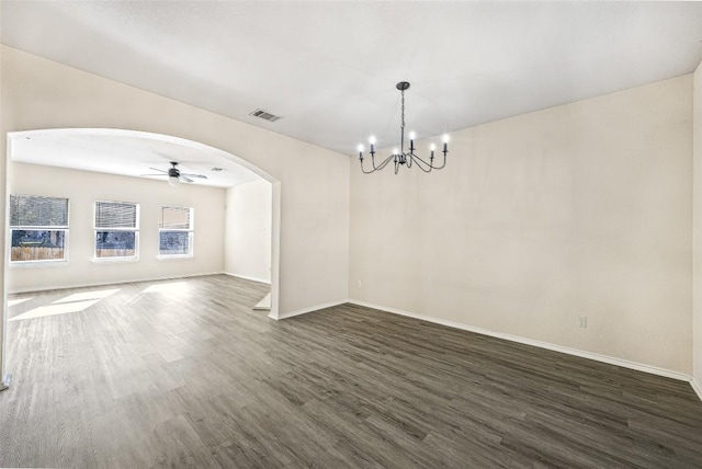 empty room featuring ceiling fan with notable chandelier and dark hardwood / wood-style flooring