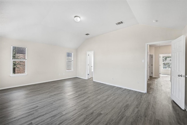 spare room featuring dark hardwood / wood-style flooring, lofted ceiling, and a wealth of natural light