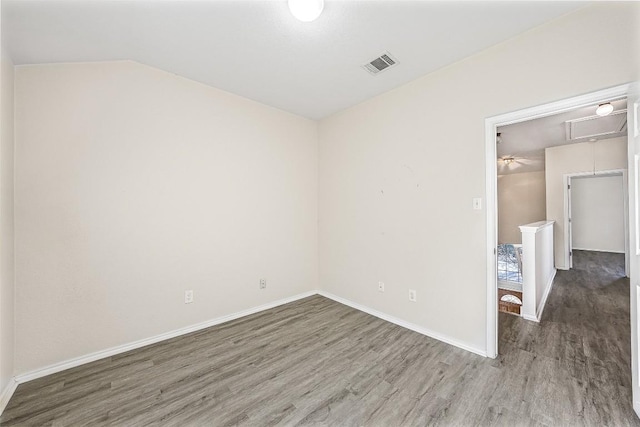 unfurnished room with dark hardwood / wood-style flooring and lofted ceiling