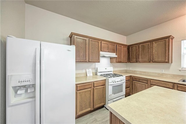 kitchen with a textured ceiling and white appliances