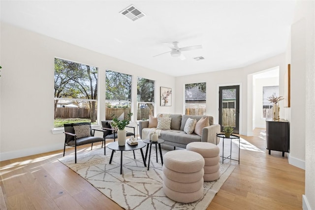 living room featuring ceiling fan, plenty of natural light, and light hardwood / wood-style flooring