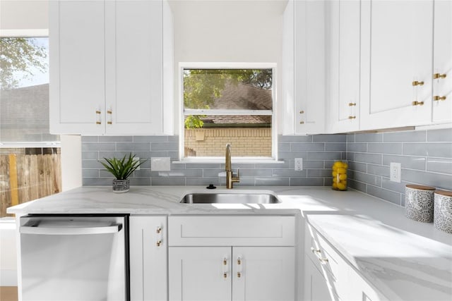 kitchen featuring a wealth of natural light, white cabinetry, sink, and stainless steel dishwasher