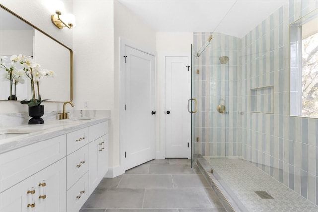 bathroom featuring tile patterned floors, plenty of natural light, a shower with door, and vanity