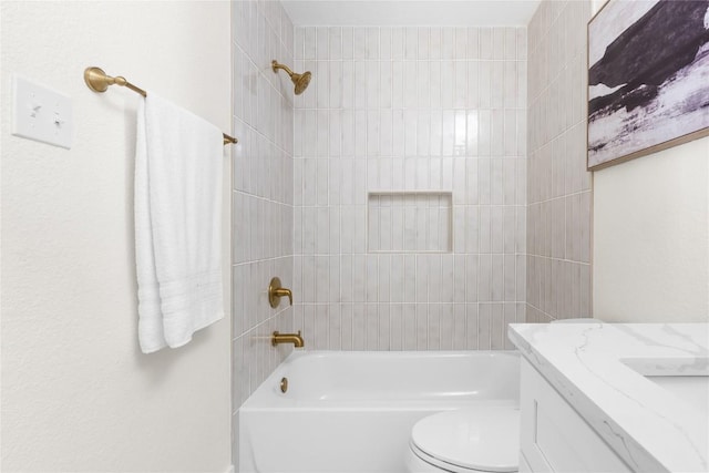 full bathroom with tiled shower / bath, vanity, and toilet