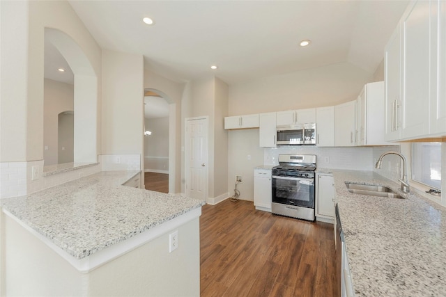 kitchen with kitchen peninsula, white cabinetry, sink, and appliances with stainless steel finishes