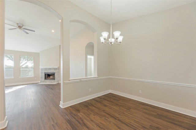 interior space featuring ceiling fan with notable chandelier, dark hardwood / wood-style flooring, and vaulted ceiling