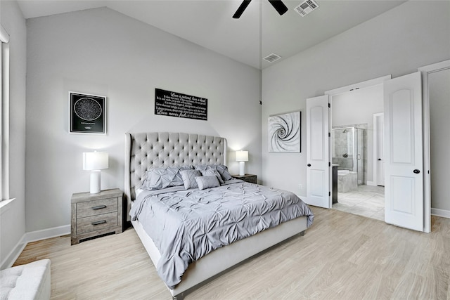 bedroom with ceiling fan, light wood-type flooring, ensuite bathroom, and lofted ceiling