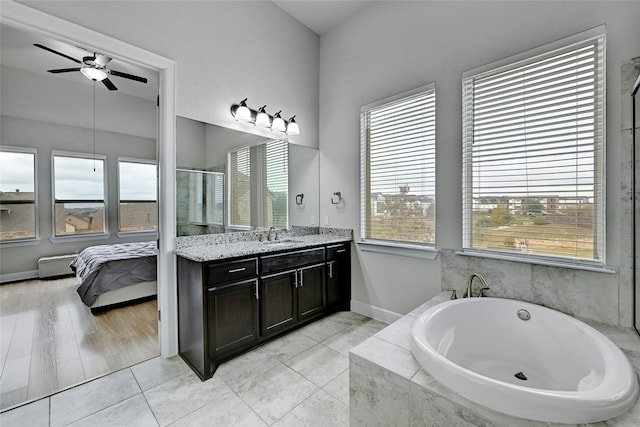 bathroom featuring vanity, tile patterned floors, ceiling fan, and a relaxing tiled tub