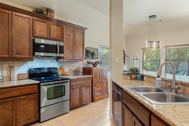 kitchen with decorative backsplash, decorative light fixtures, sink, and appliances with stainless steel finishes