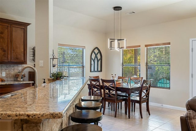 dining room featuring sink and light tile patterned flooring