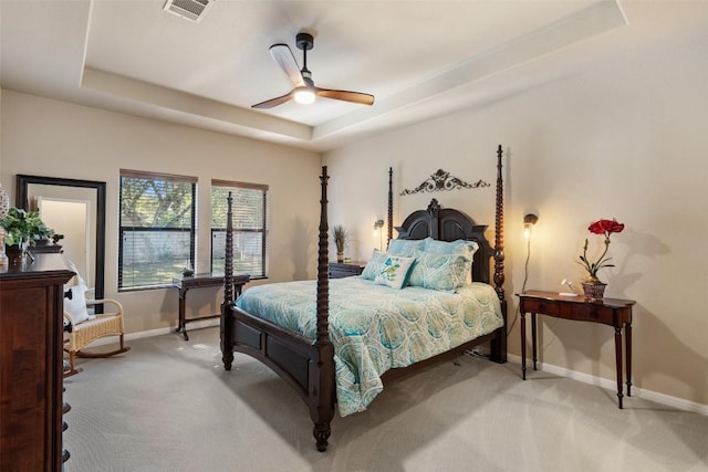 bedroom featuring a tray ceiling, ceiling fan, and light carpet