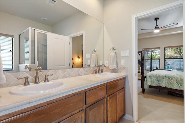 bathroom featuring plenty of natural light, ceiling fan, a shower with shower door, and vanity