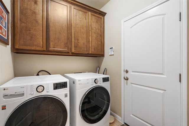 laundry room with cabinets and washer and clothes dryer