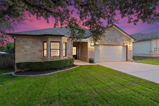 ranch-style home with a garage and a yard