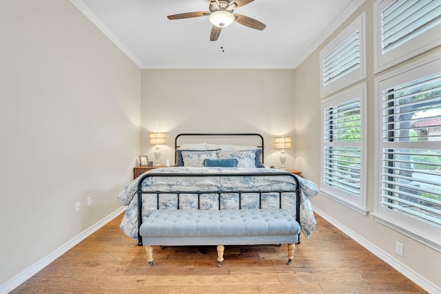 bedroom with ceiling fan, crown molding, and light hardwood / wood-style floors