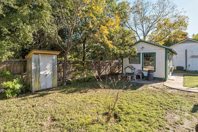 view of yard with central AC and a storage shed