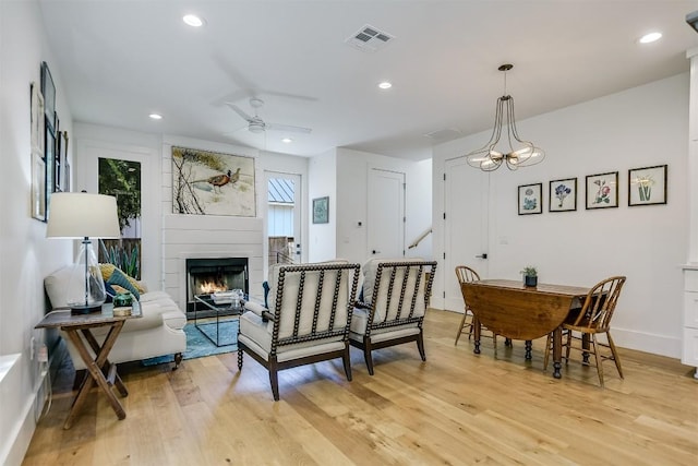 interior space with ceiling fan with notable chandelier, light hardwood / wood-style floors, and a healthy amount of sunlight