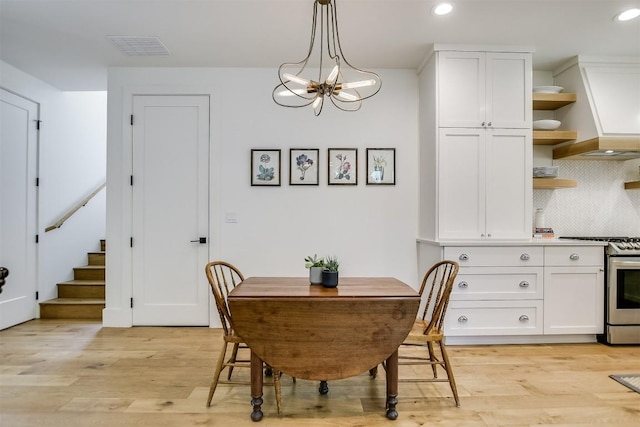 dining space featuring light hardwood / wood-style floors and an inviting chandelier