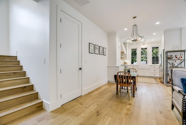 dining room with a chandelier, sink, and light hardwood / wood-style floors