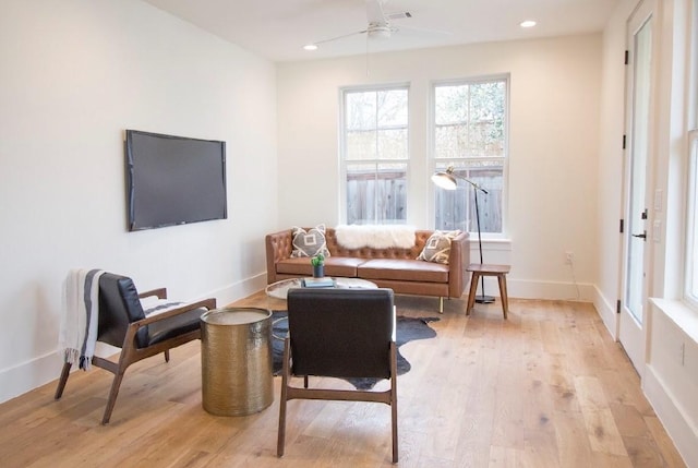 living area featuring light wood-type flooring and ceiling fan